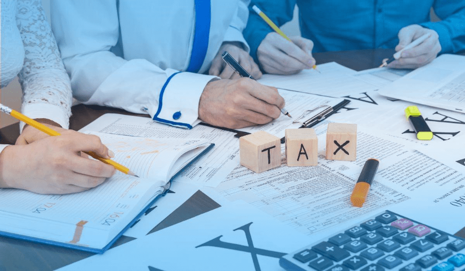 People reviewing tax documents and calculations at a desk